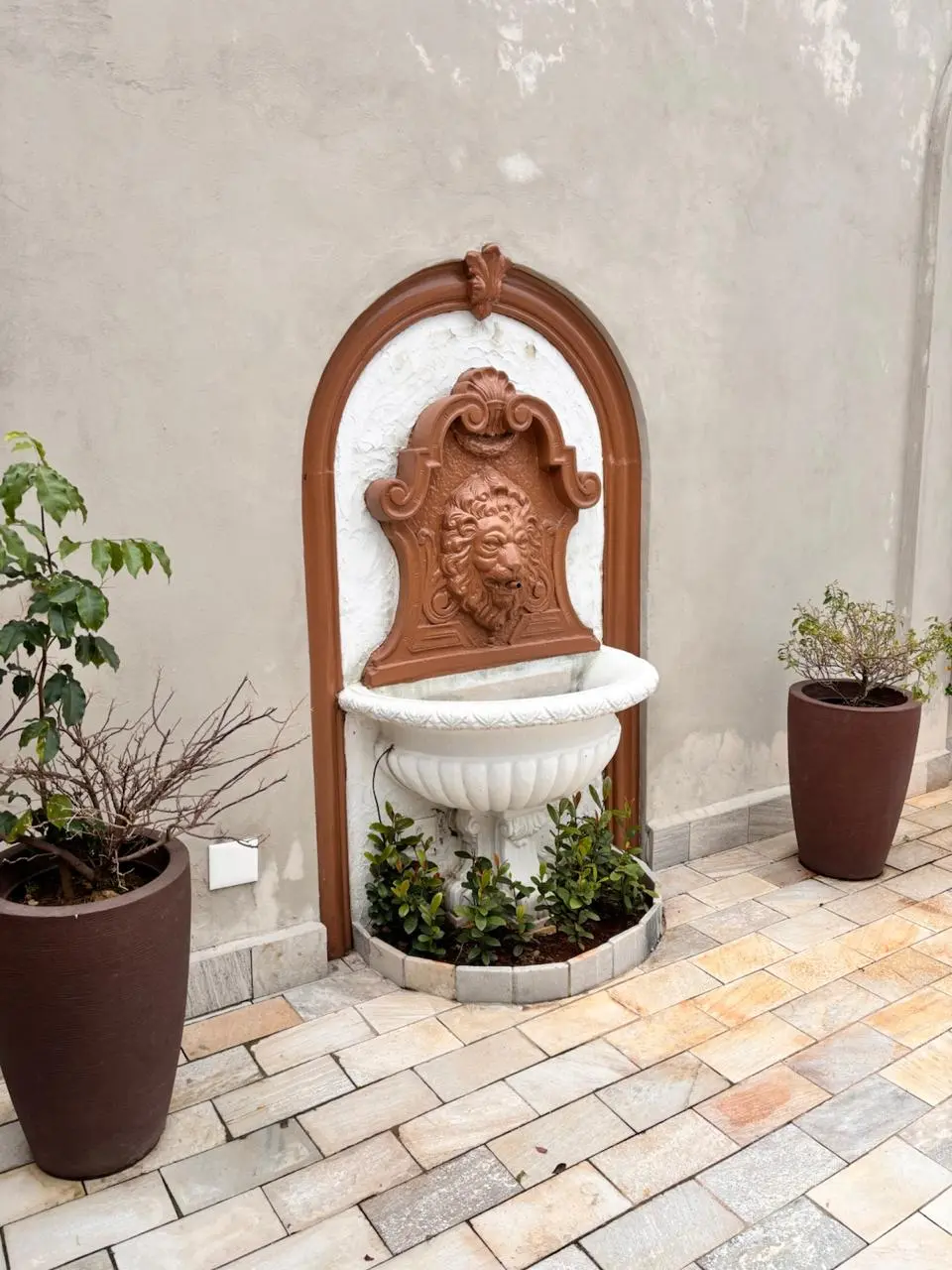 Área externa renovada com fonte ornamental e vasos