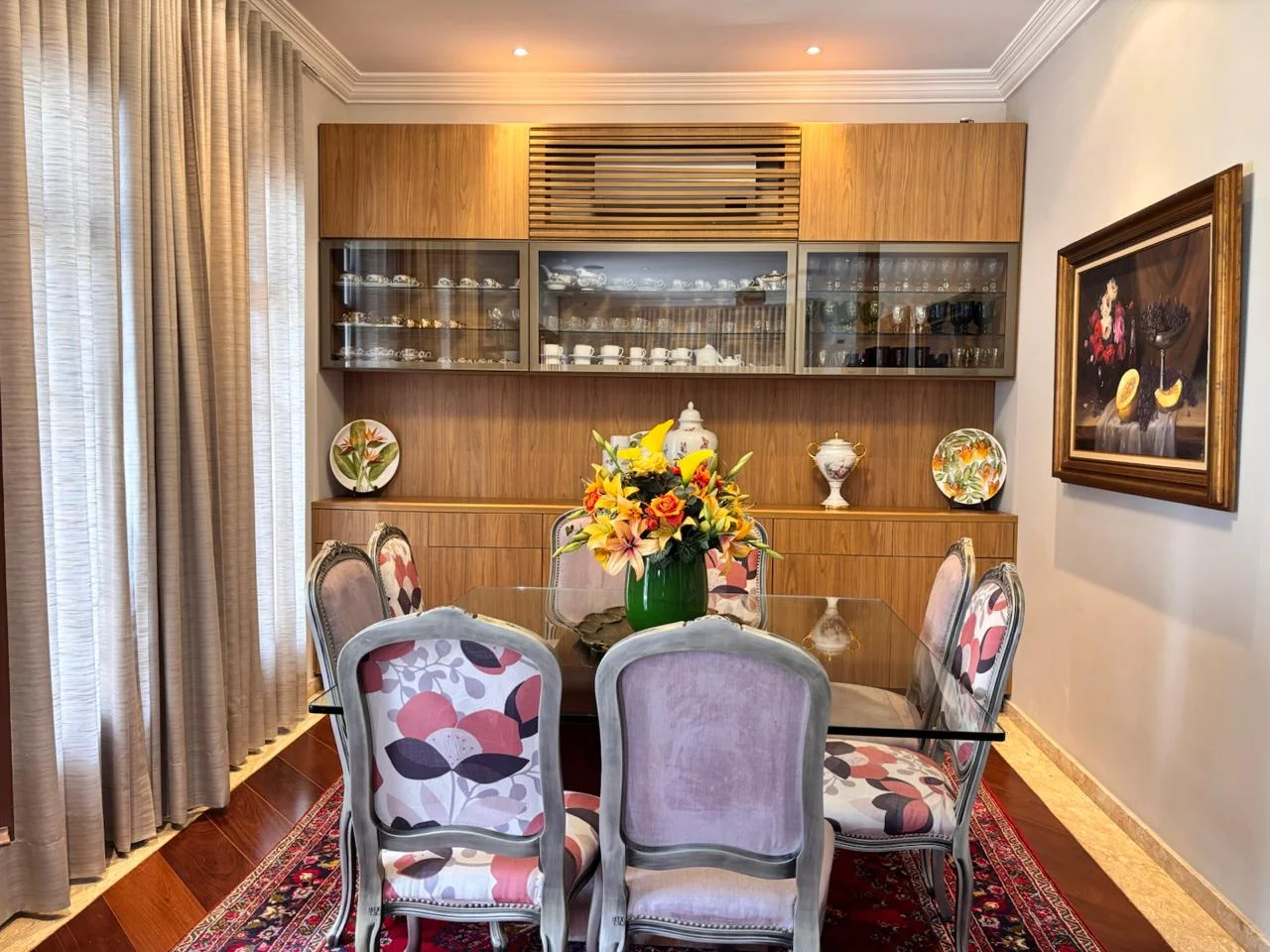 Sala de jantar com mesa de madeira e objetos pessoais