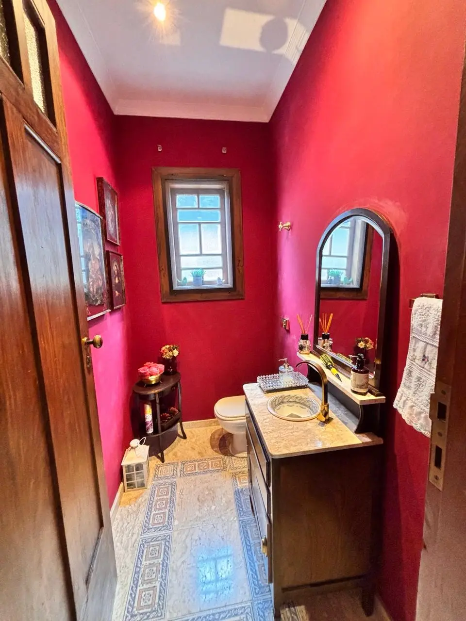 Lavabo com paredes em tom marcante, madeira e detalhes decorativos