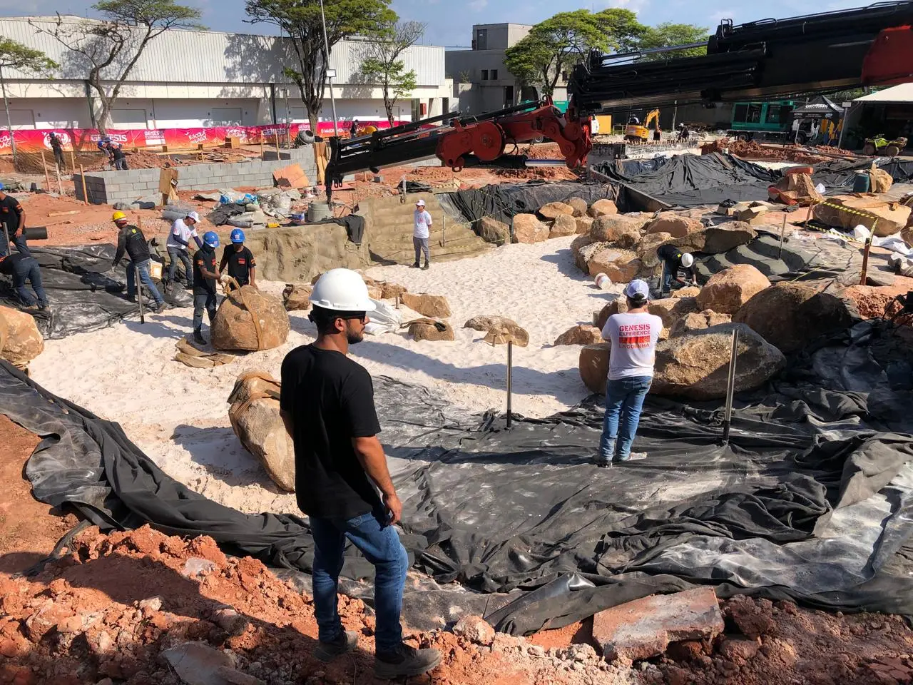 Implantação do lago com estruturas, impermeabilização, pedras e equipes em obra