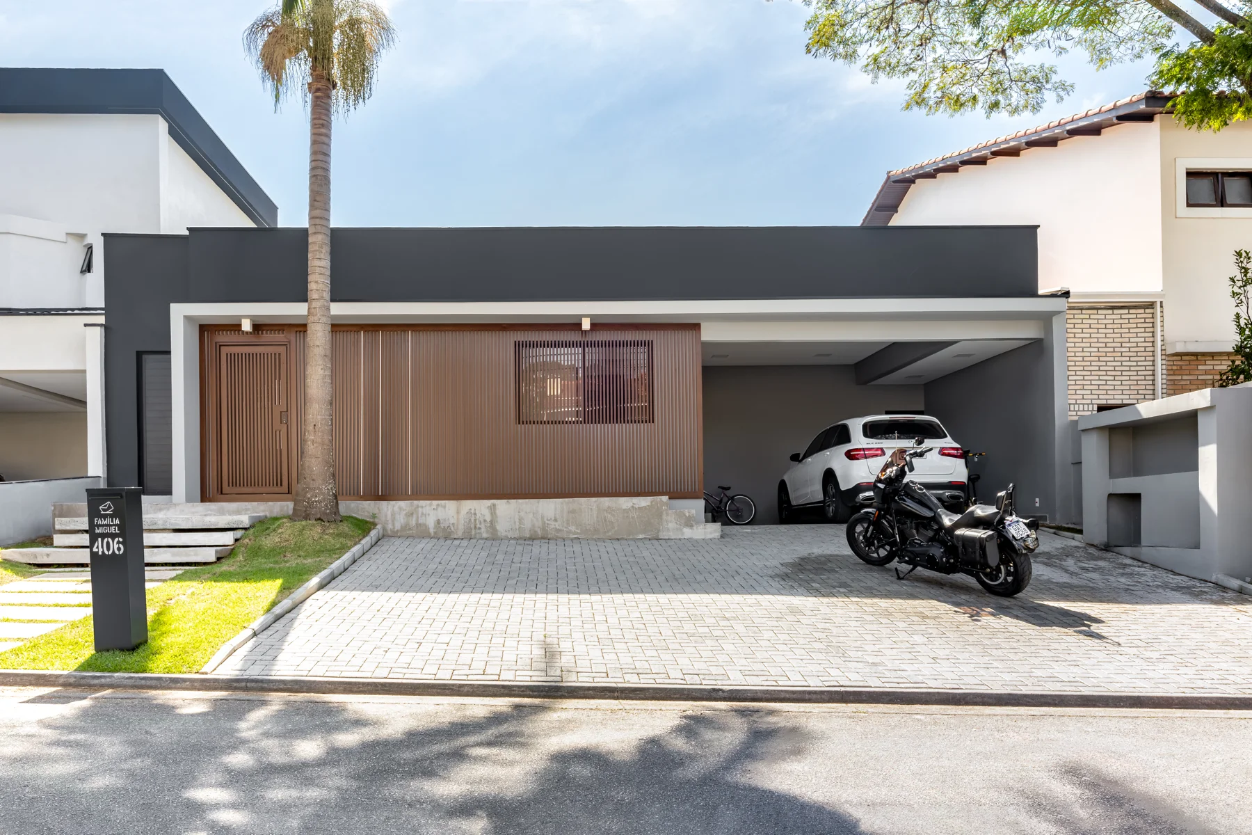 Fachada contemporânea com ripado e paisagismo, retrofit em Alphaville